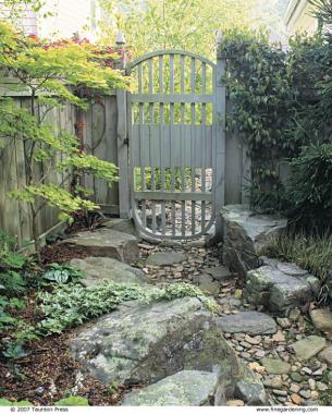 With some flat stepping stones, this streambed doubles as a garden path. The see-through, flow-through gate handles rising water while securing the backyard.