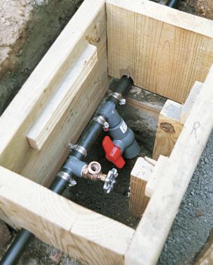 The main connection box at the center of the garden has both a spigot (for running water to the sprinkler) and a drain valve